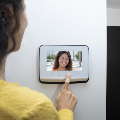 lady opening to a visitor on somfy video door phone