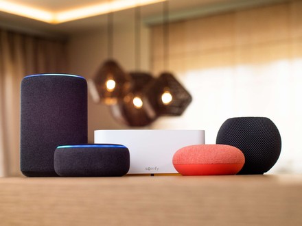  Centralka TaHoma Somfy do sterowania smart home i inteligentne głośniki ustawione na blacie.